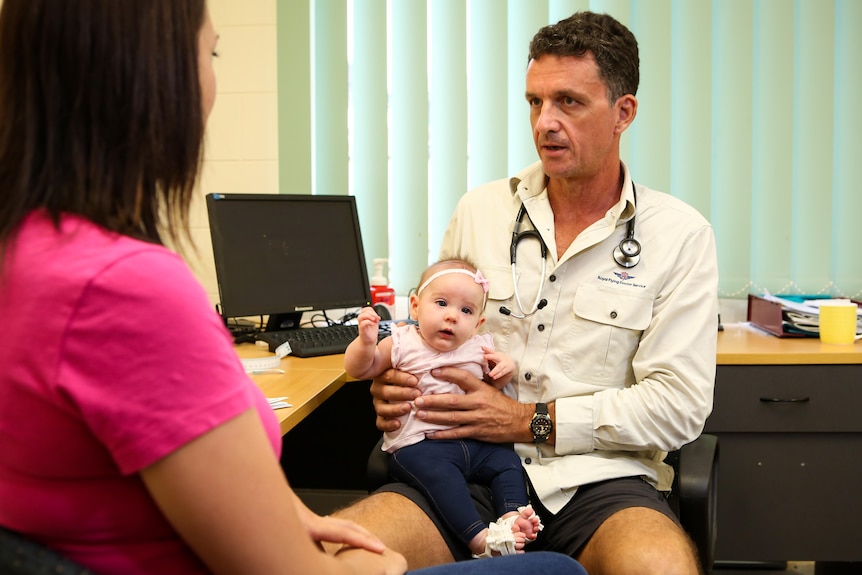 baby with its dad in a doctor's office