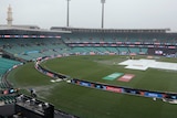 Water gathers on the ground as covers are on the pitch at the SCG before the T20 World Cup semis.