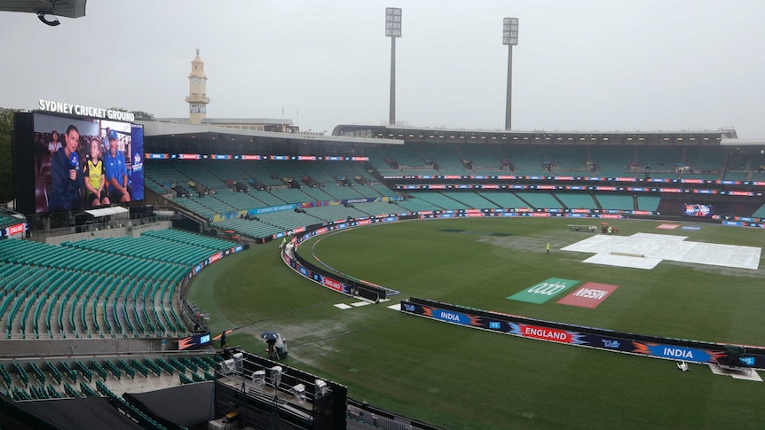 Water gathers on the ground as covers are on the pitch at the SCG before the T20 World Cup semis.