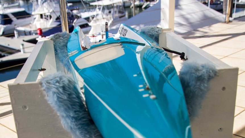 A remote-controlled yacht sits in a box.