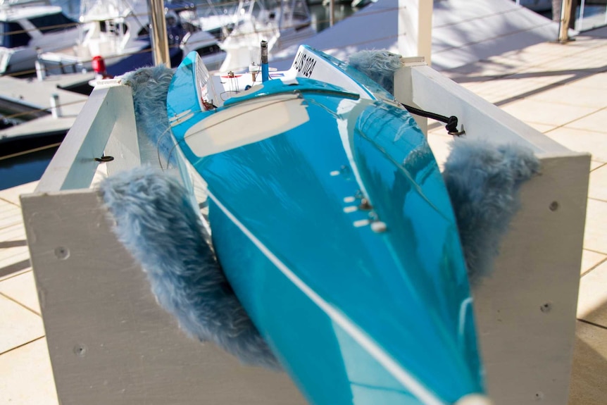 A remote-controlled yacht sits in a box.