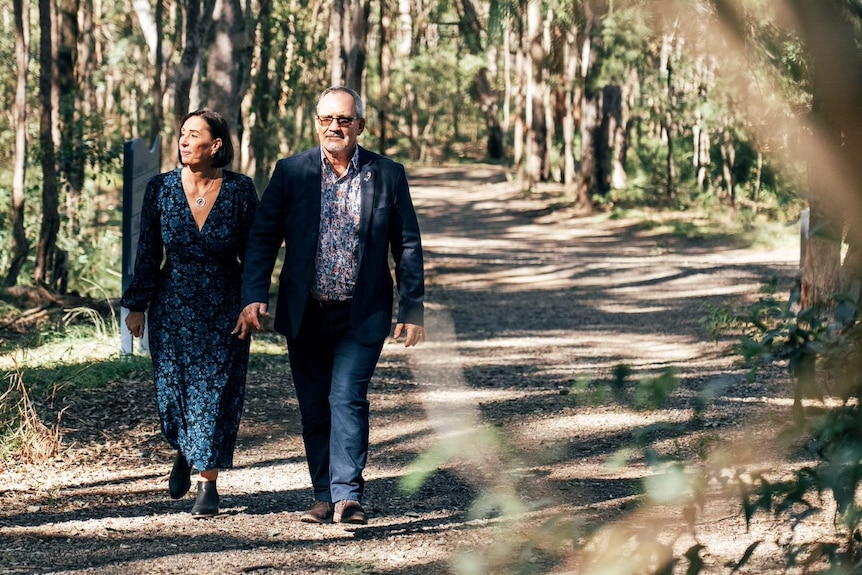 Sue and Lloyd Clarke walk through bushland.