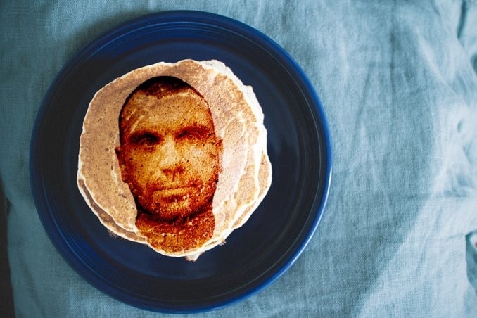 A superimposed photo of a man on a stake of pancakes.