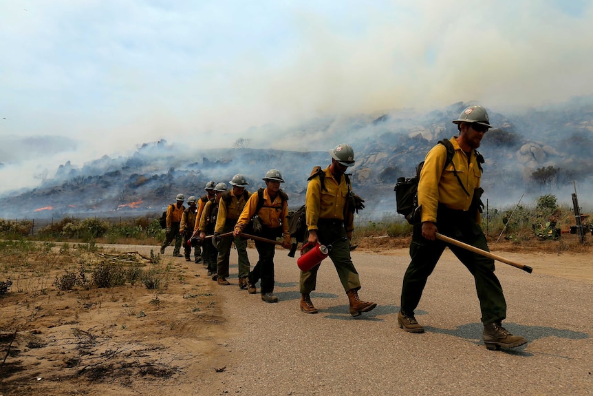 US Forest Service firefighters walk to their truck after battling a wildfire.