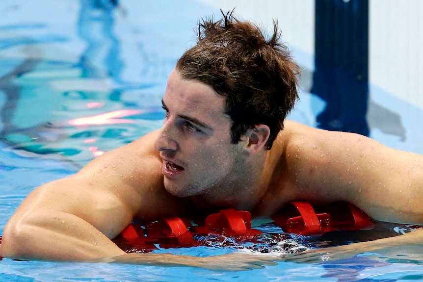 James Magnussen rests on the lane rope after coming second in the men's 100m freestyle final. (Reuters: Tim Wimborne)