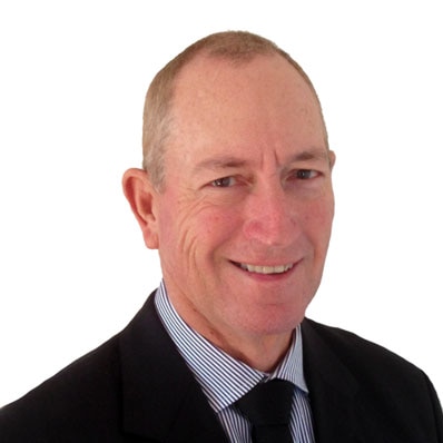 Fraser Anning, photographed against a white background, wearing a black suit and and tie with a striped shirt.