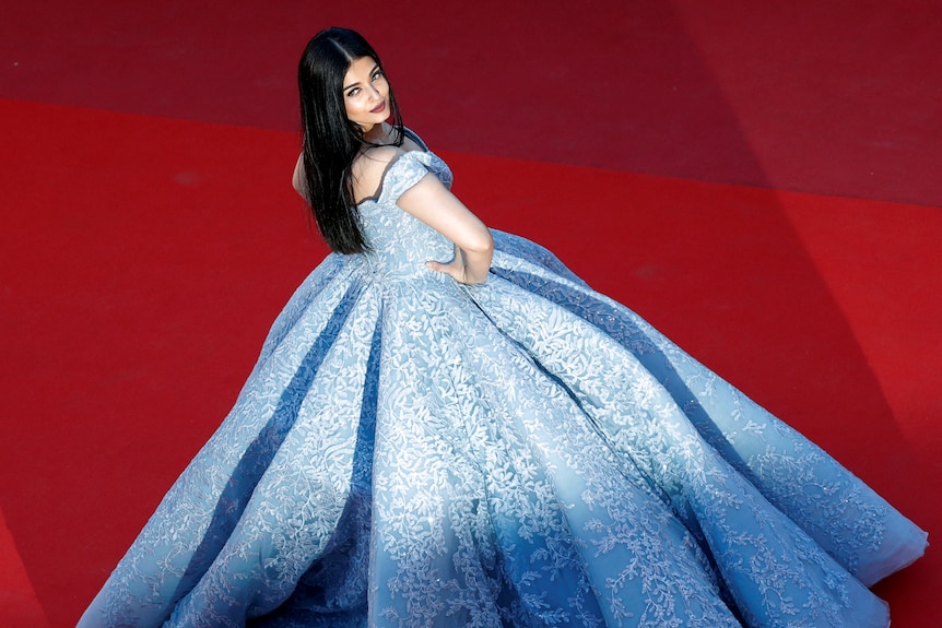 Above view of a woman in a blue ball gown on a red carpet. 