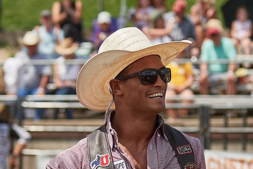 A portrait of a cowboy in a rodeo arena