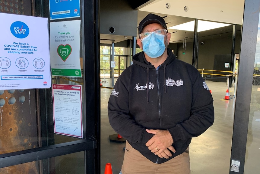 a man in a mask standing in a doorway