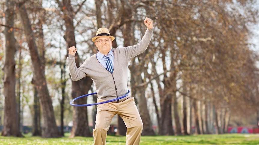 A senior man playing with a hula hoop