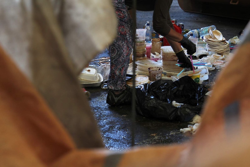 A view of a volunteer collecting straws from amid towers of containers.