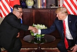 Kim Jong-un shakes hands with Donald Trump.