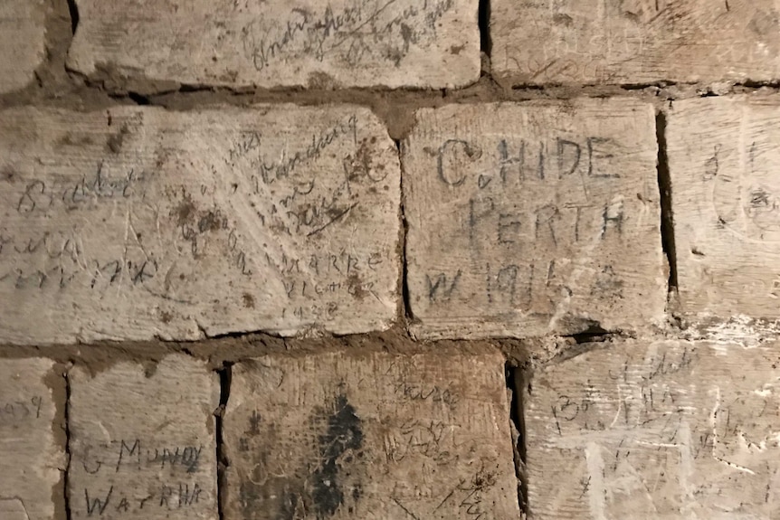 Etchings on the brick walls of ancient tunnels.