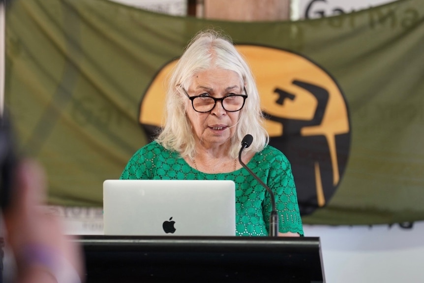Marcia Langton speaks at a lectern with a laptop open in front of her. She is wearing a green top
