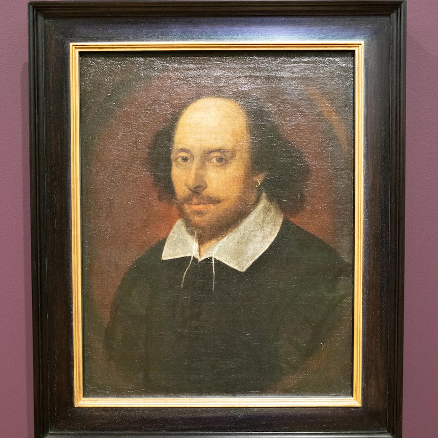 An old portrait of William Shakespeare, with a balding middle head and wearing a white collared short under a black cape.