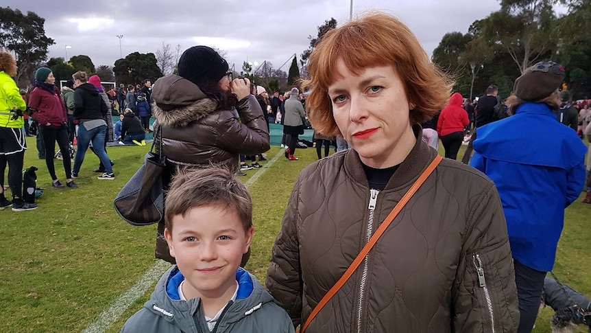 Chantel Camilleri stands with her son Gene amongst vigil attendees at Princes Park.