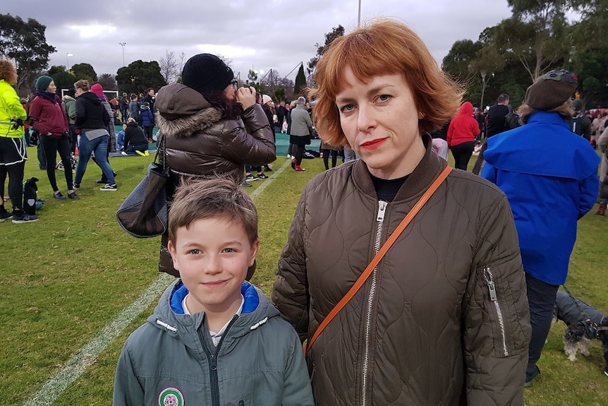 Chantel Camilleri stands with her son Gene amongst vigil attendees at Princes Park.