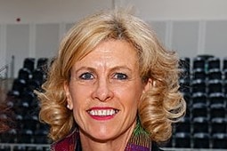 A woman with blonde hair smiles at the camera 