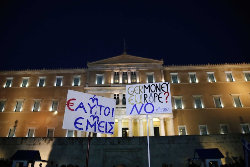 Protesters hold banners in front of the parliament building in Greece