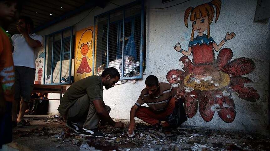 Scouts collect the remains of bodies at a bombed UN-run school sheltering Palestinians displaced by an Israeli ground offensive.