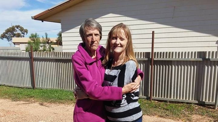 A mother and daughter embrace.