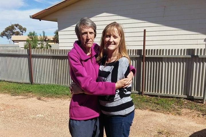 A mother and daughter embrace.