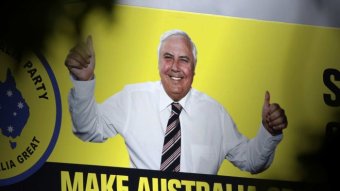 A canary yellow billboard with Clive Palmer giving the thumbs up.
