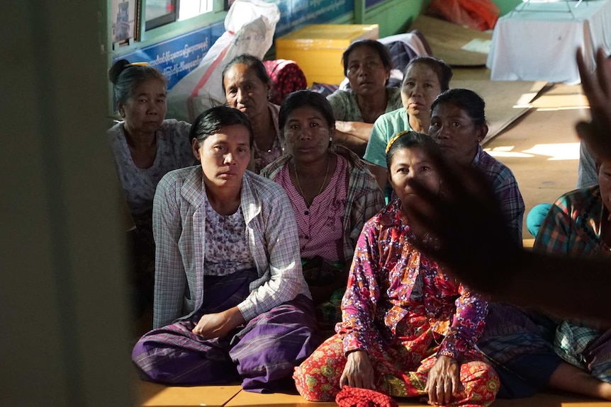 A group of locals sit together on the floor