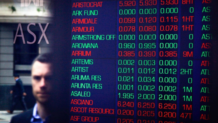 Pedestrians are reflected in the window of the Australian Securities Exchange (ASX) next to a board displaying stock prices