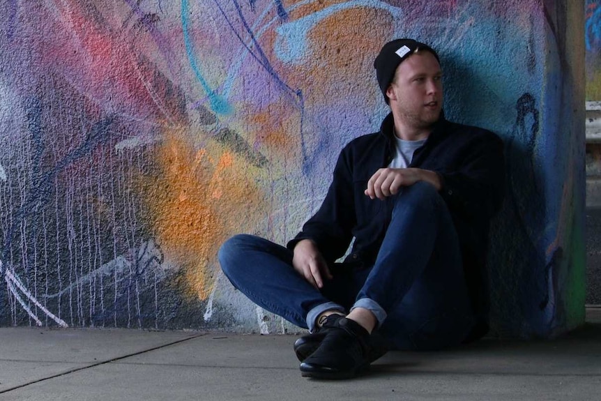 Jack Nagle sits in front of a mural