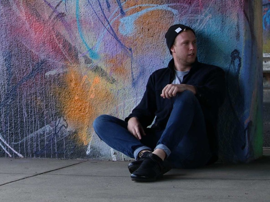 Jack Nagle sits in front of a mural