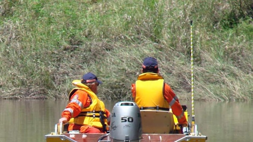 An SES crew make their way through floodwaters