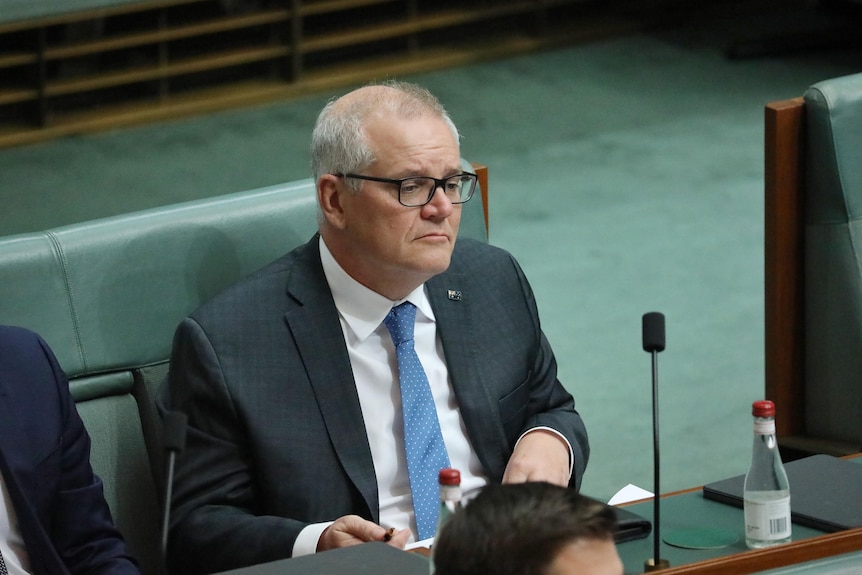 Scott Morrison sitting on the backbench in parliament house 
