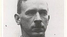 A profile of Percy Stephensen with a hair cut and moustache bearing a likeness of Adolf Hitler