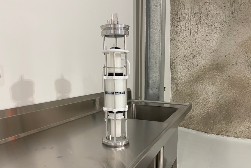 a silver piece of scientific equipment that looks like a large cannister.