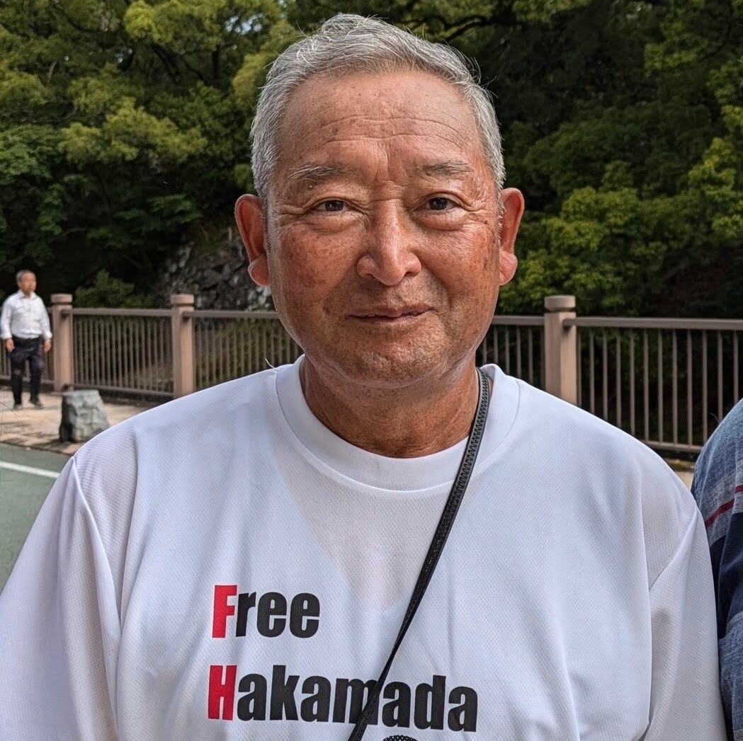 A Japanese man wearing a "free Hakamada" t-shirt.