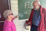 woman and man chat outside flood meeting