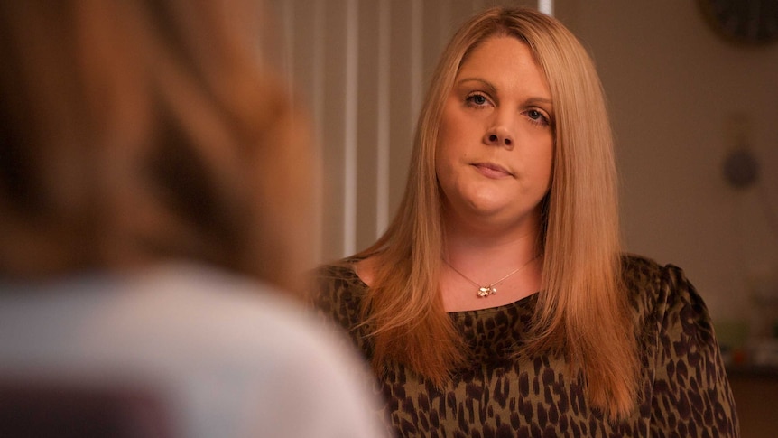 A woman wearing an animal print top.