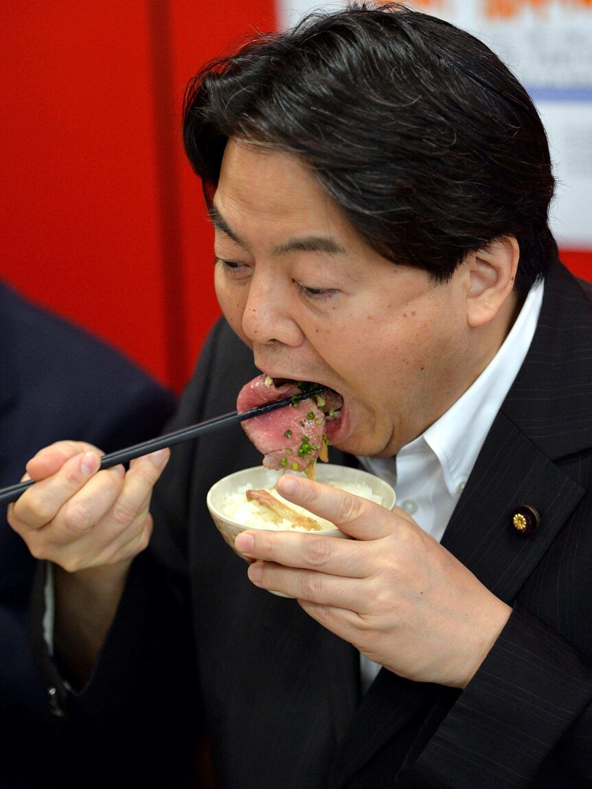 Japanese Agriculture Minister Yoshimasa Hayashi eats whale meat during a promotion in Tokyo.