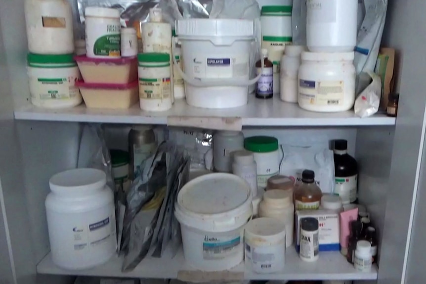 Shelves packed with assorted containers of chemicals, stored messily.