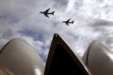 A Qantas Airways and an Emirates Airlines Airbus A380 fly above the Sydney Opera House.
