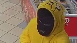 CCTV image of a man in a yellow jumpsuit and black face mask holding a handgun