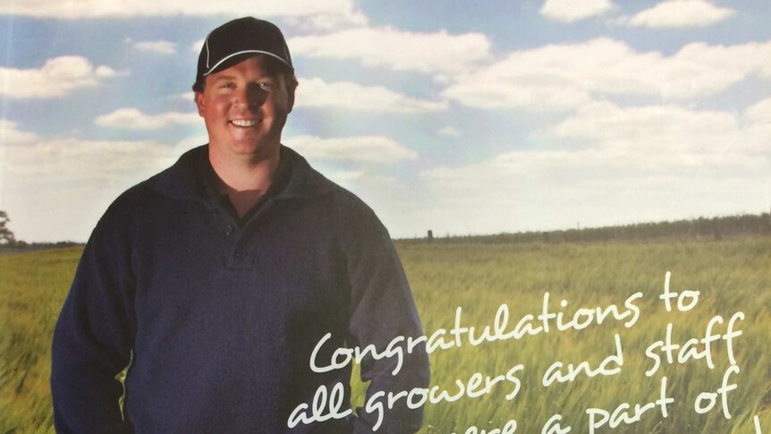 Grain grower stands waist deep in a paddock of wheat.