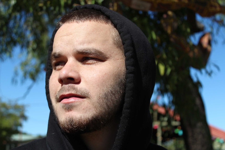 A close up head shot of hip hop artist Tasman Keith, looking into the distance.