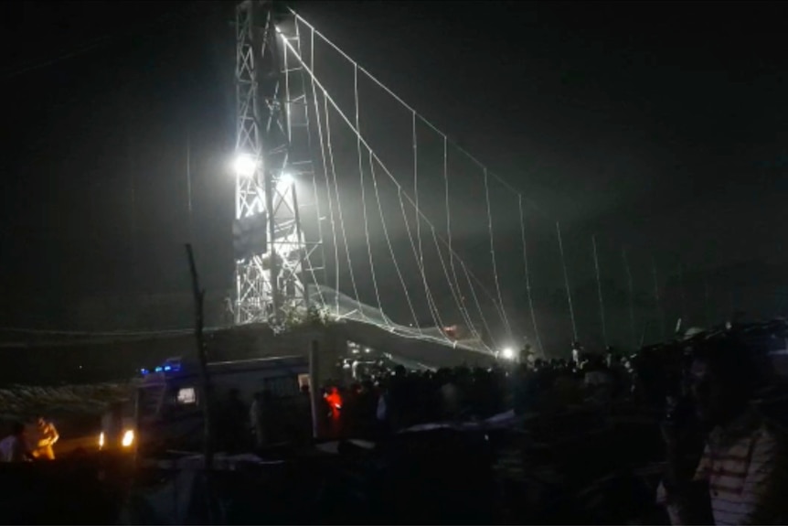 Los equipos de rescate trabajan de noche después del colapso de un puente sobre el río Machu en Morbi.