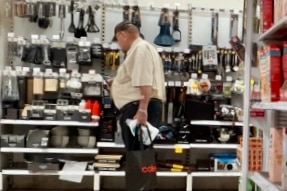 A wide shot of a man in a supermarket