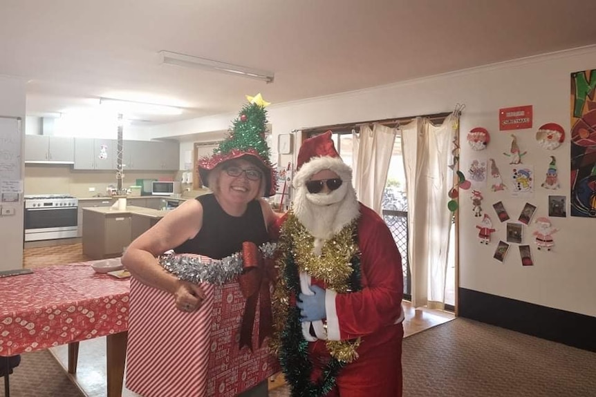 Disability worker dressed in Christmas attire with a client.