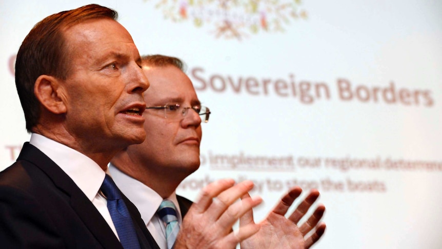 Tony Abbott speaks next to Scott Morrison in front of an Operation Sovereign Borders poster