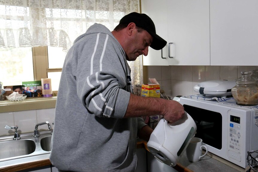 Mark Brewer making a cup of tea in his kitchen.