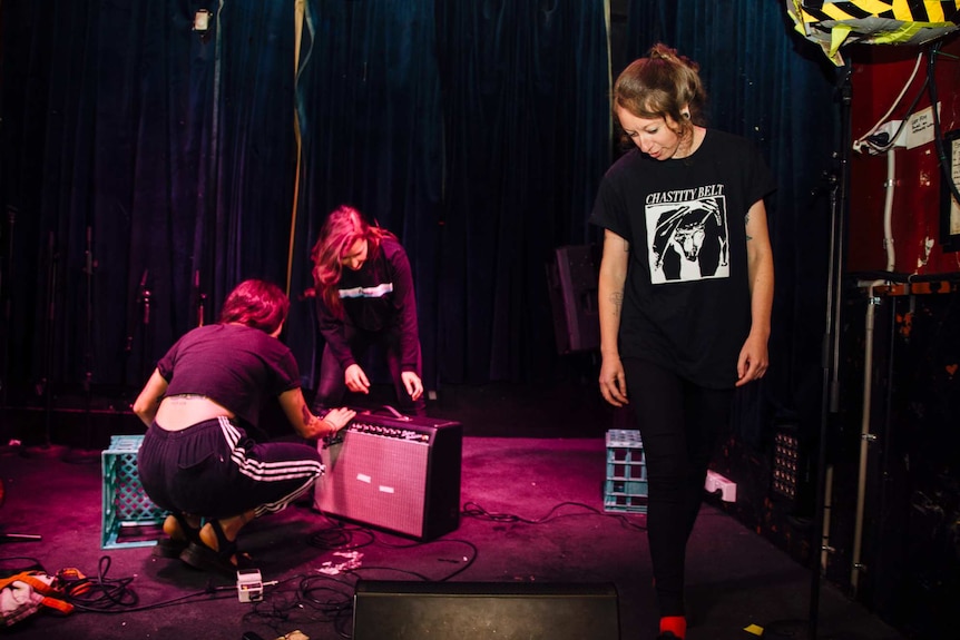 Camp Cope band members set up for a rehearsal